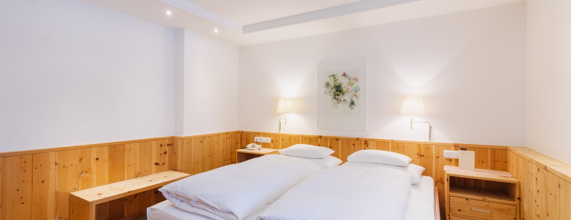Schlafzimmer mit Bett in der Mitte, Junior Suite mit Balkon Das Schlafzimmer der Junior Suite mit Balkon mit Doppelbett in der Mitte