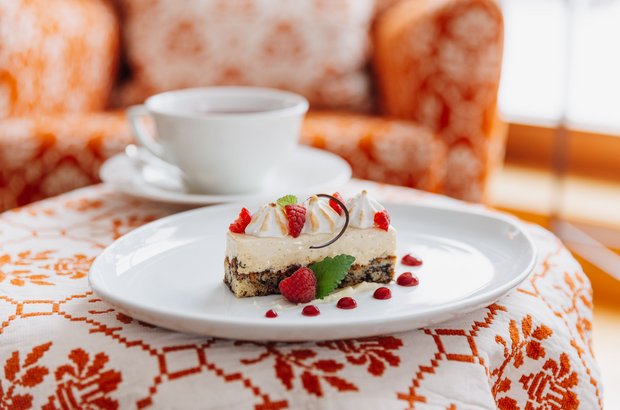 Kuchen und Kaffee im Kaminzimmer Ein Teller mit einem Kuchen und eine Tasse