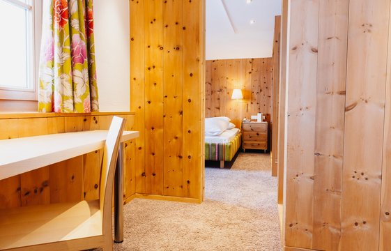 Junior Suite mit Stuhl und Tisch im Vordergrund Junior Suite mit Stuhl und Tisch im Vordergrund links