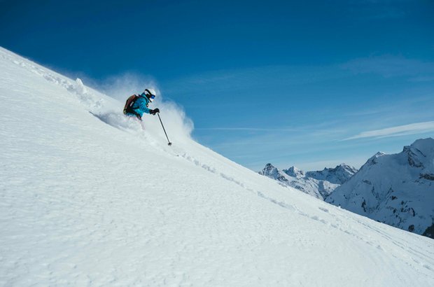 Abfahrt im Tiefschnee Ein Skifahrer macht einen Abfahrt im Tiefschnee