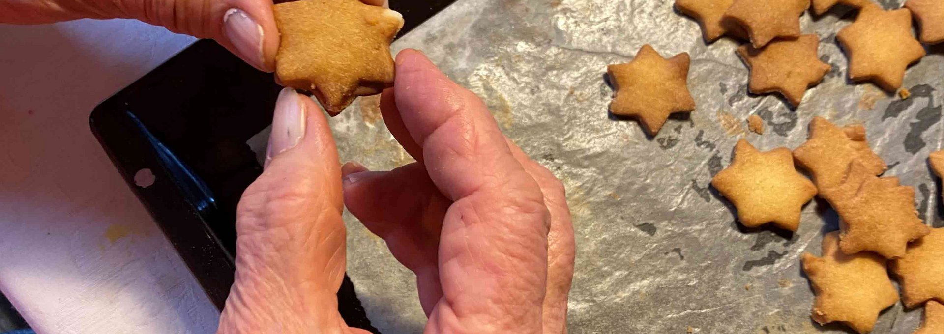 Kekse backen zu Weihnachten Zwei Hände halten einen Weihnachtskeks