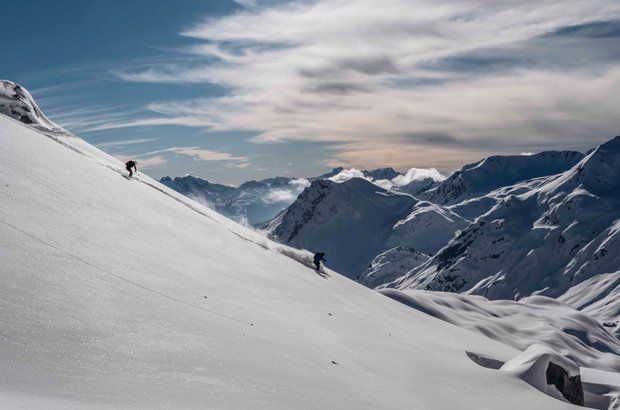 Skifahren abseits der Piste Eine Person fährt mit Skiern einen verschneiten Berg hinunter